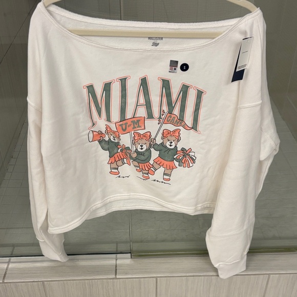 Hollister Tops - NWT Ivory Graphic Miami Hurricanes Off the shoulder cropped sweatshirt
